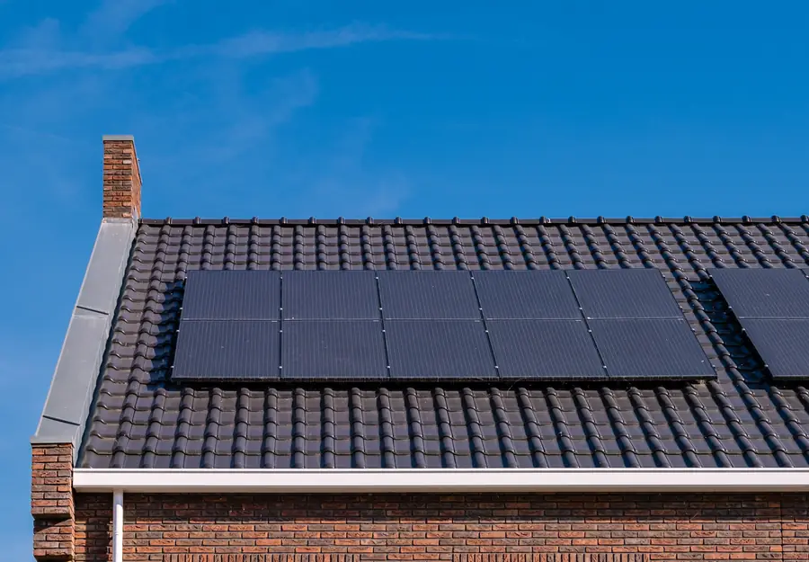 Black solar panels fitted to a tiled roof